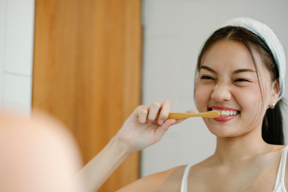 mujer lavándose los dientes para evitar manchas en los dientes
