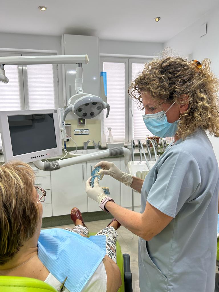 Dentista en Propiodent enseñando a paciente protesis dental